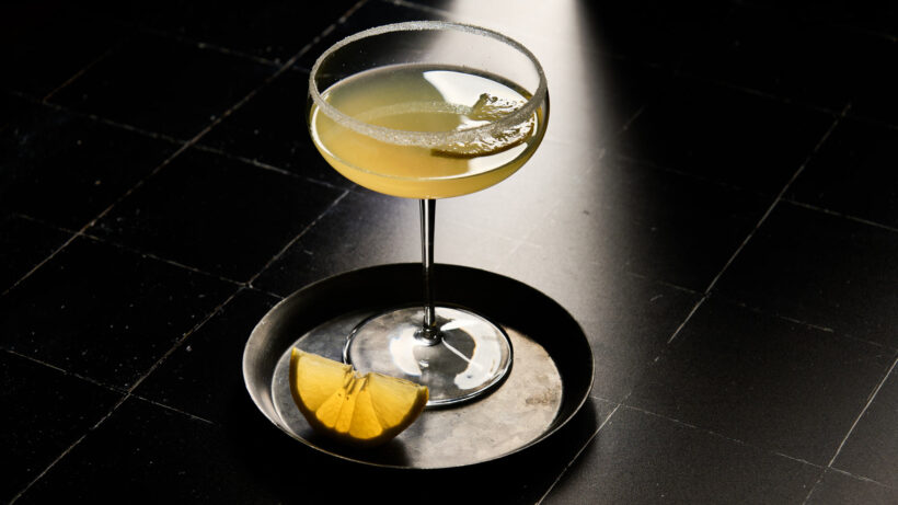 Lemon Drop Martini in a dark room, silhouetted by a spotlight.