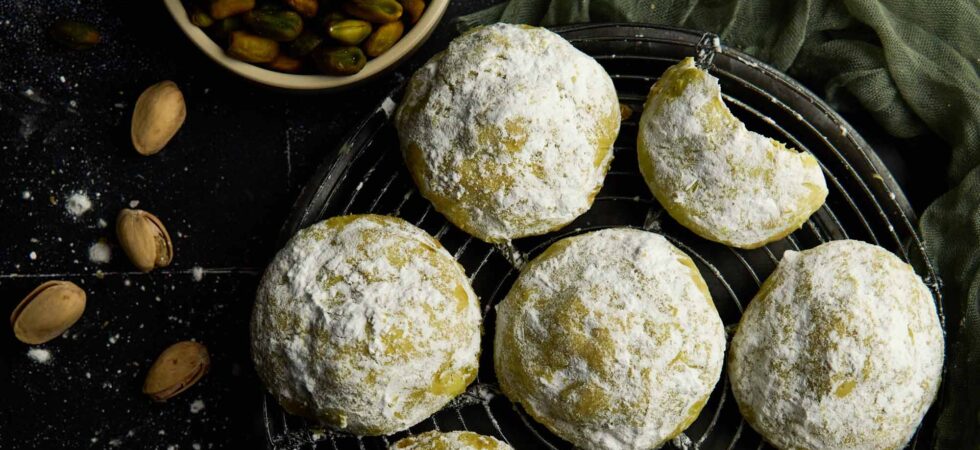 Pistachio snowball cookies on a wire rack