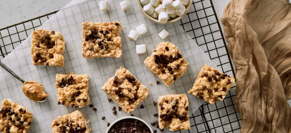 Avalanche Bars on a cooling rack with mini marshmallows, mini chocolate morsels, and a spoonful of peanut butter.