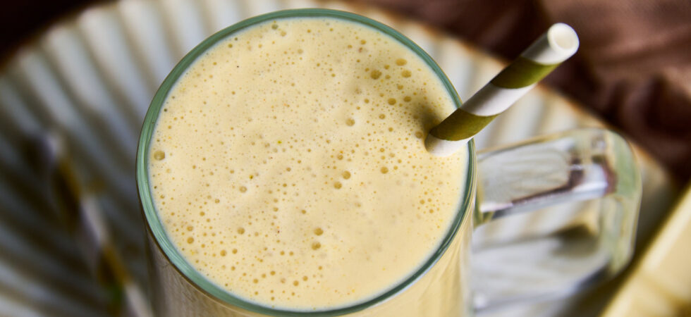 Close-up of a Pistachio-White Chocolate Milkshake with a gold and white straw.