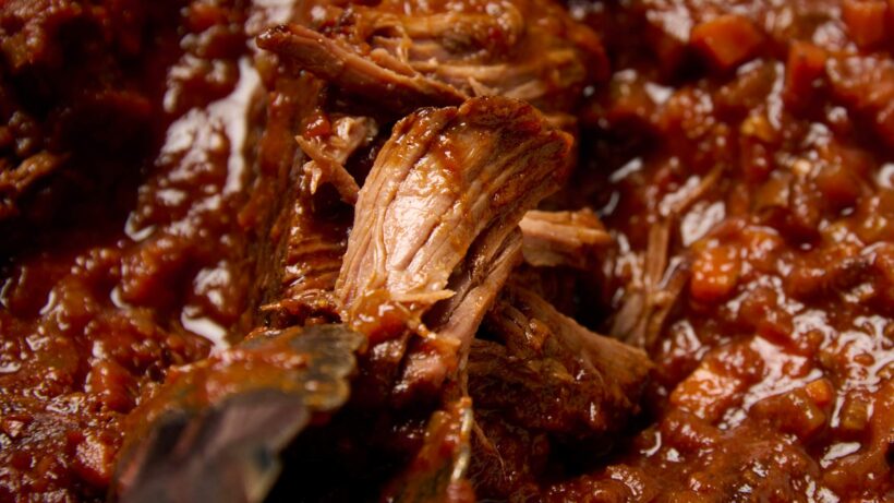 shredding braised beef ragù for plating.