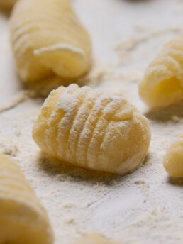 Close up of homemade potato gnocchi sprinkled with flour.