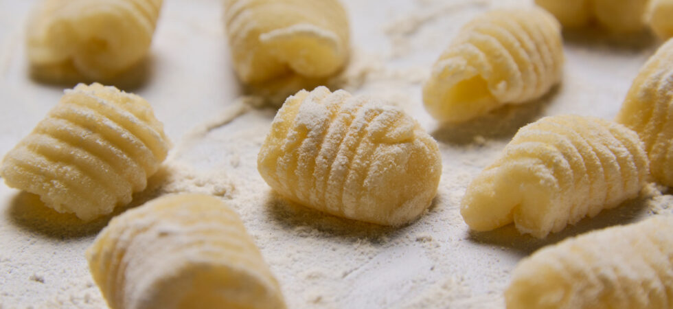 Close up of homemade potato gnocchi sprinkled with flour.