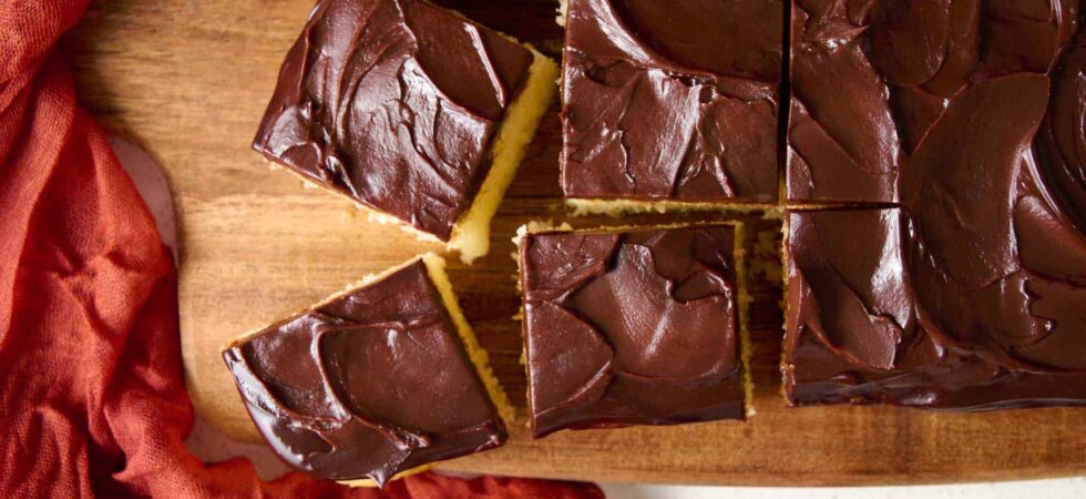 Dark Chocolate Ganache Frosting spread over a cake and cut into square pieces