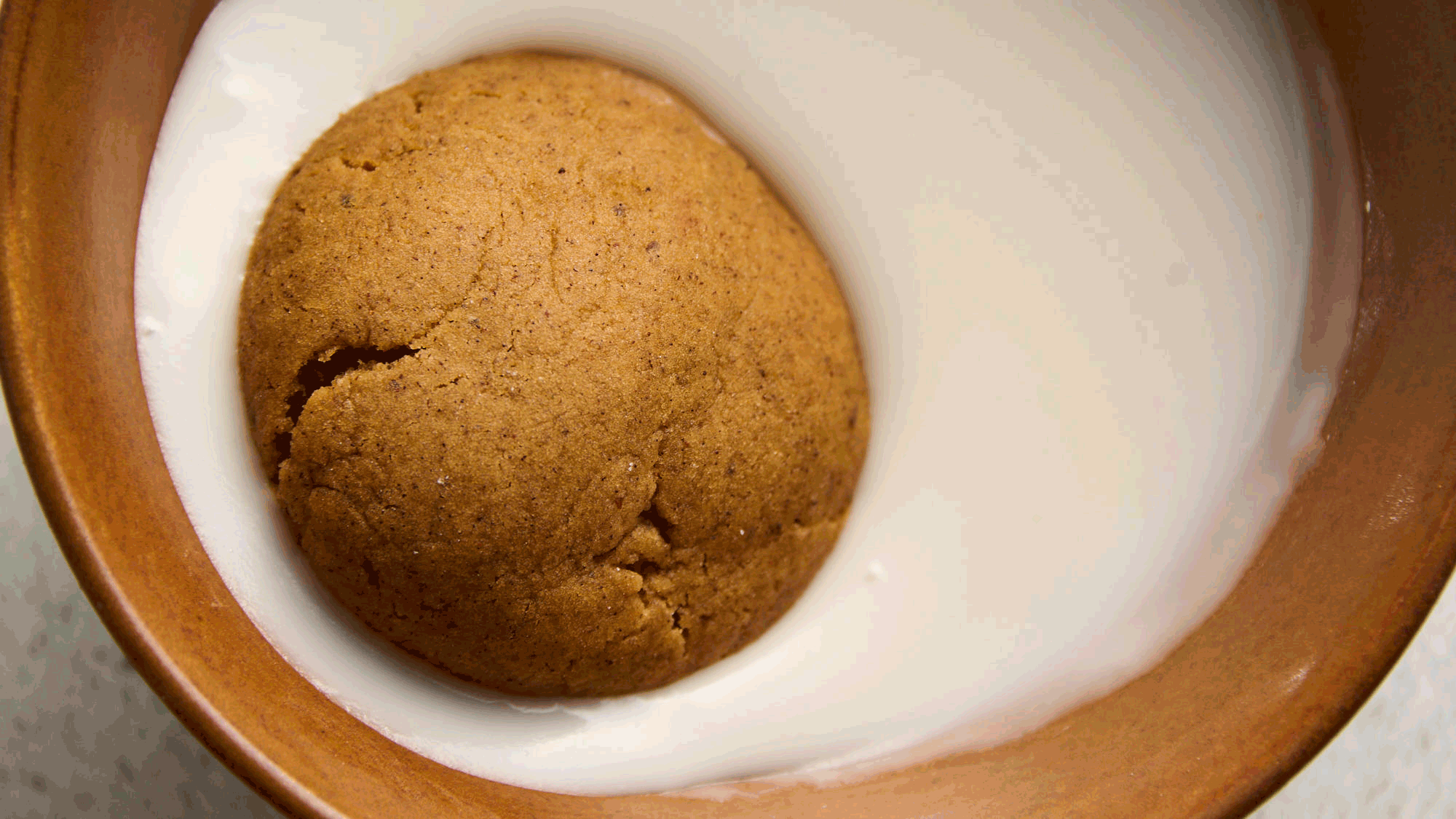 Pfeffernusse Cookies being dipped in glaze
