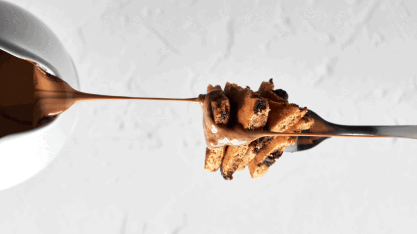 A biteful of peanut butter chocolate chip pancakes on a fork.